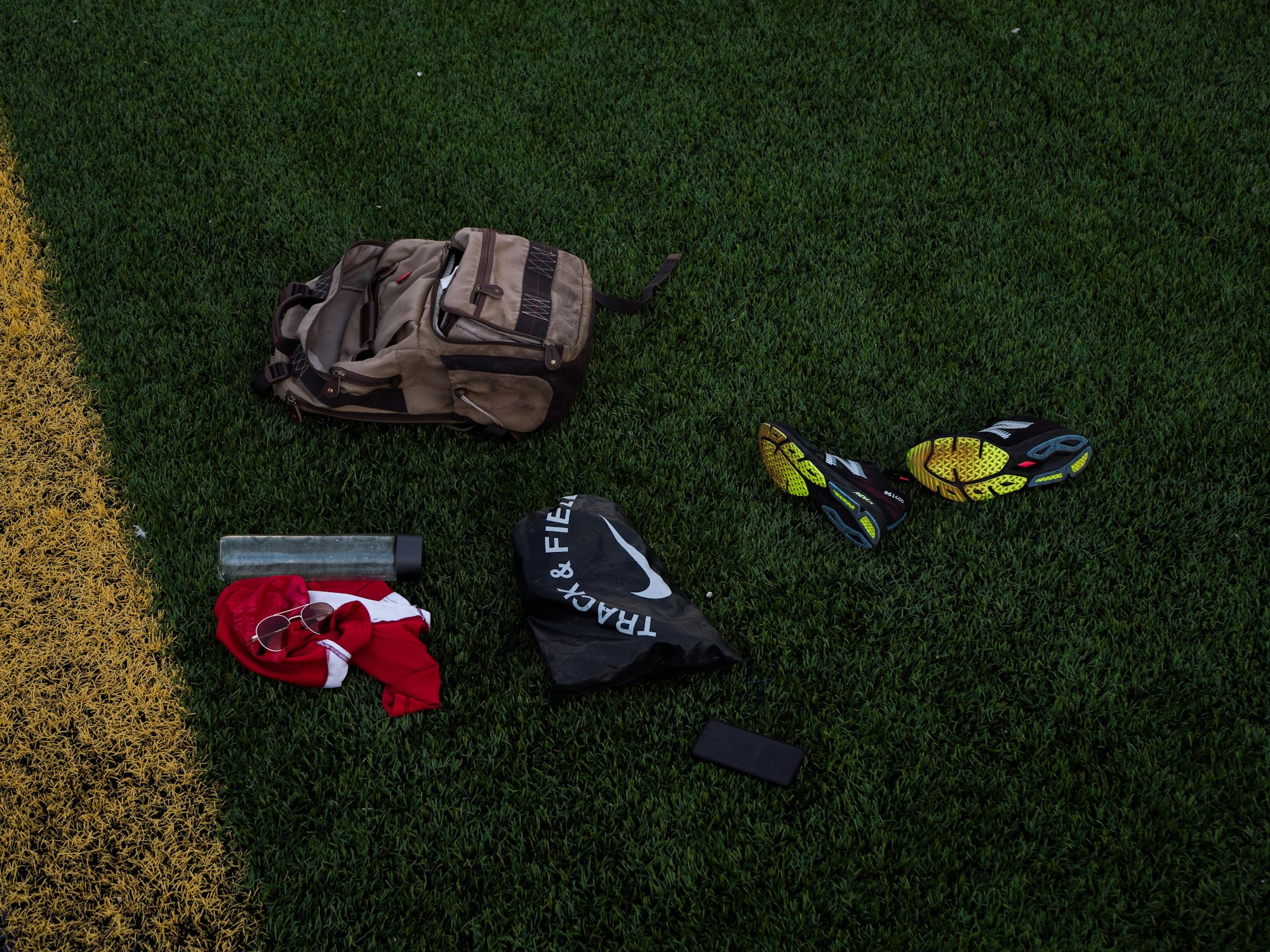 Brown and black backpack on green grass