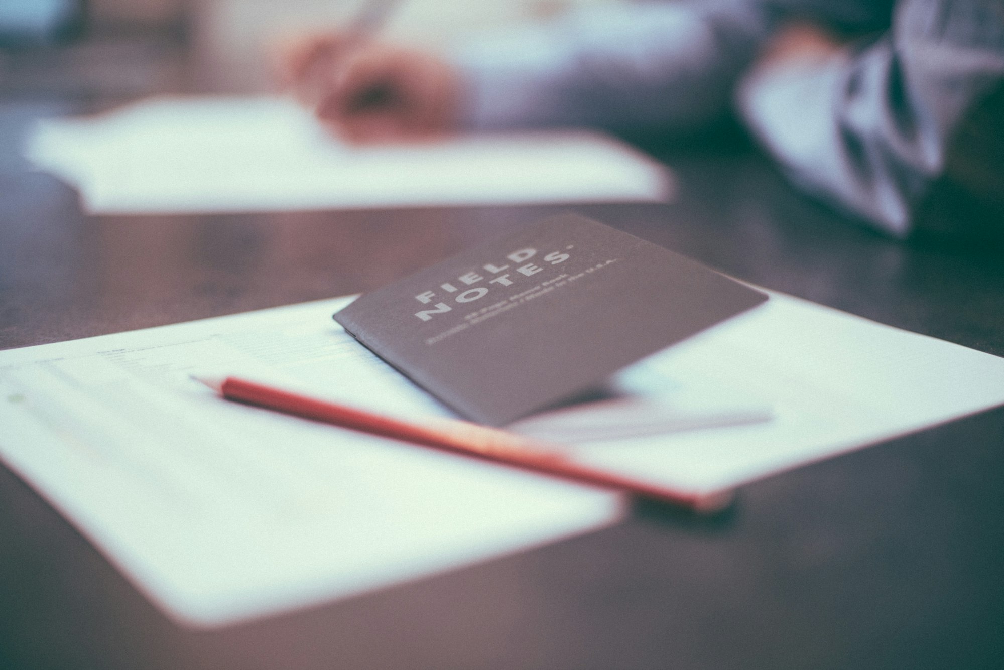 a pencil resting on an open pocket notebook