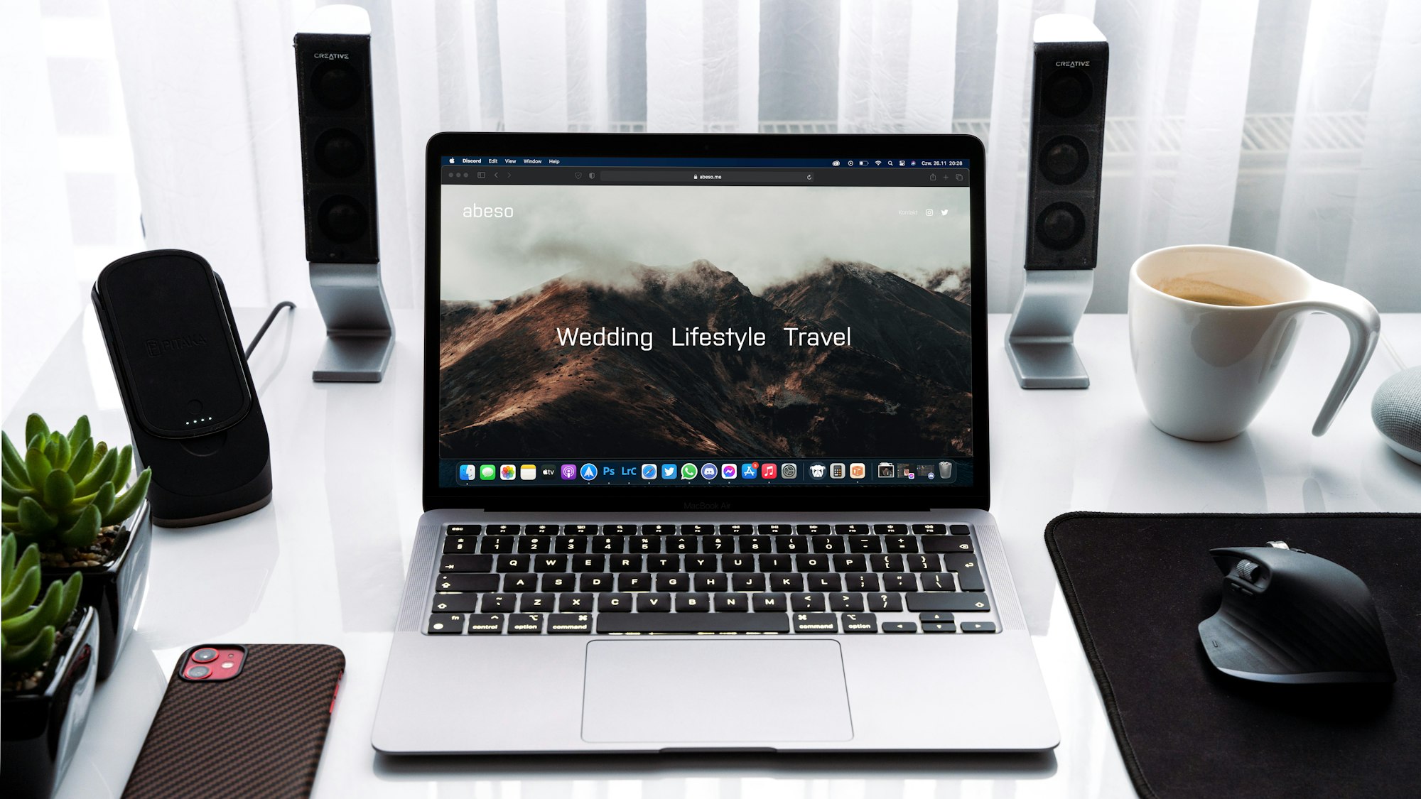 MacBook Pro beside white ceramic mug on desk