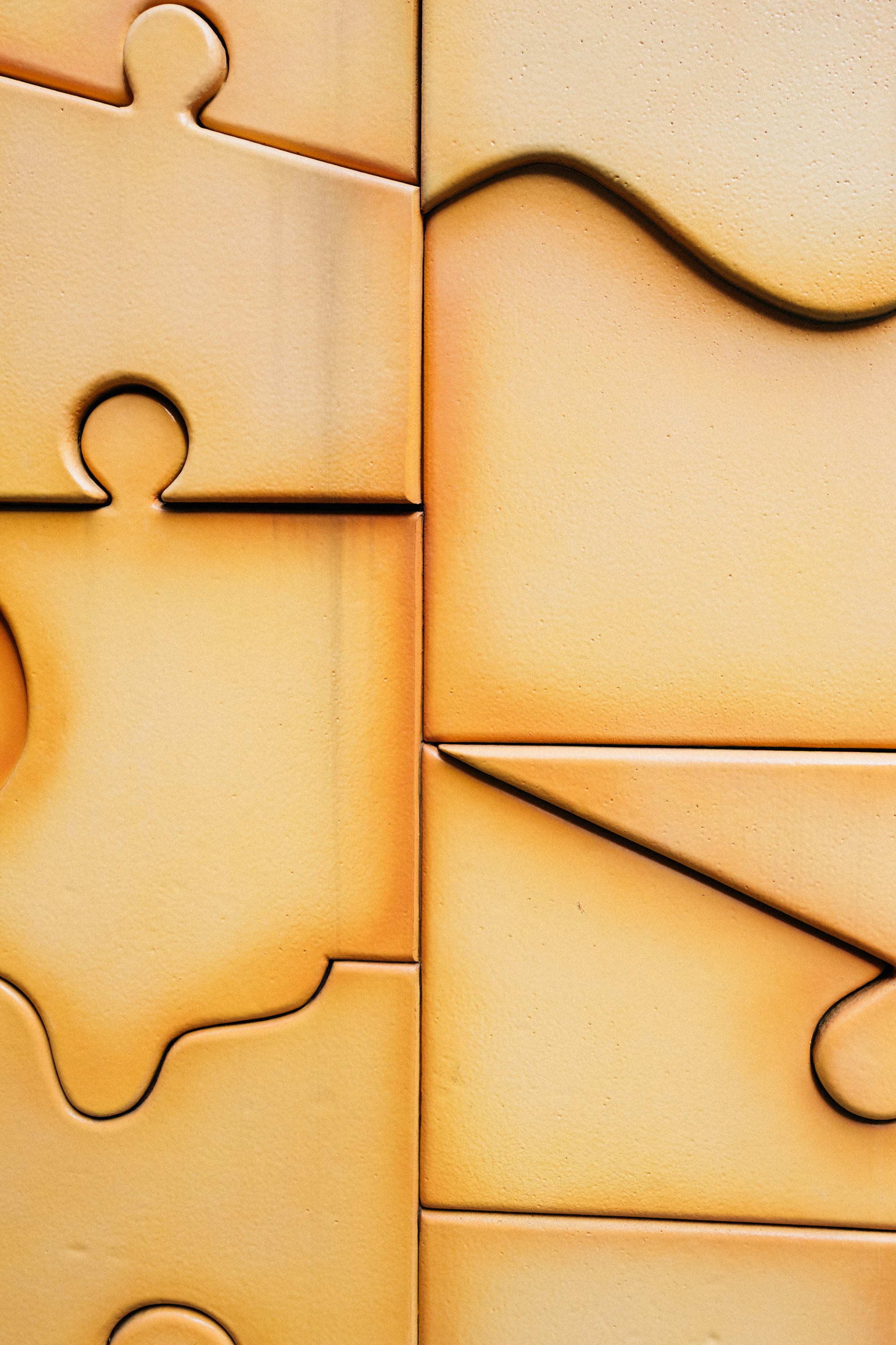 Close-up of interlocking puzzle pieces with warm lighting