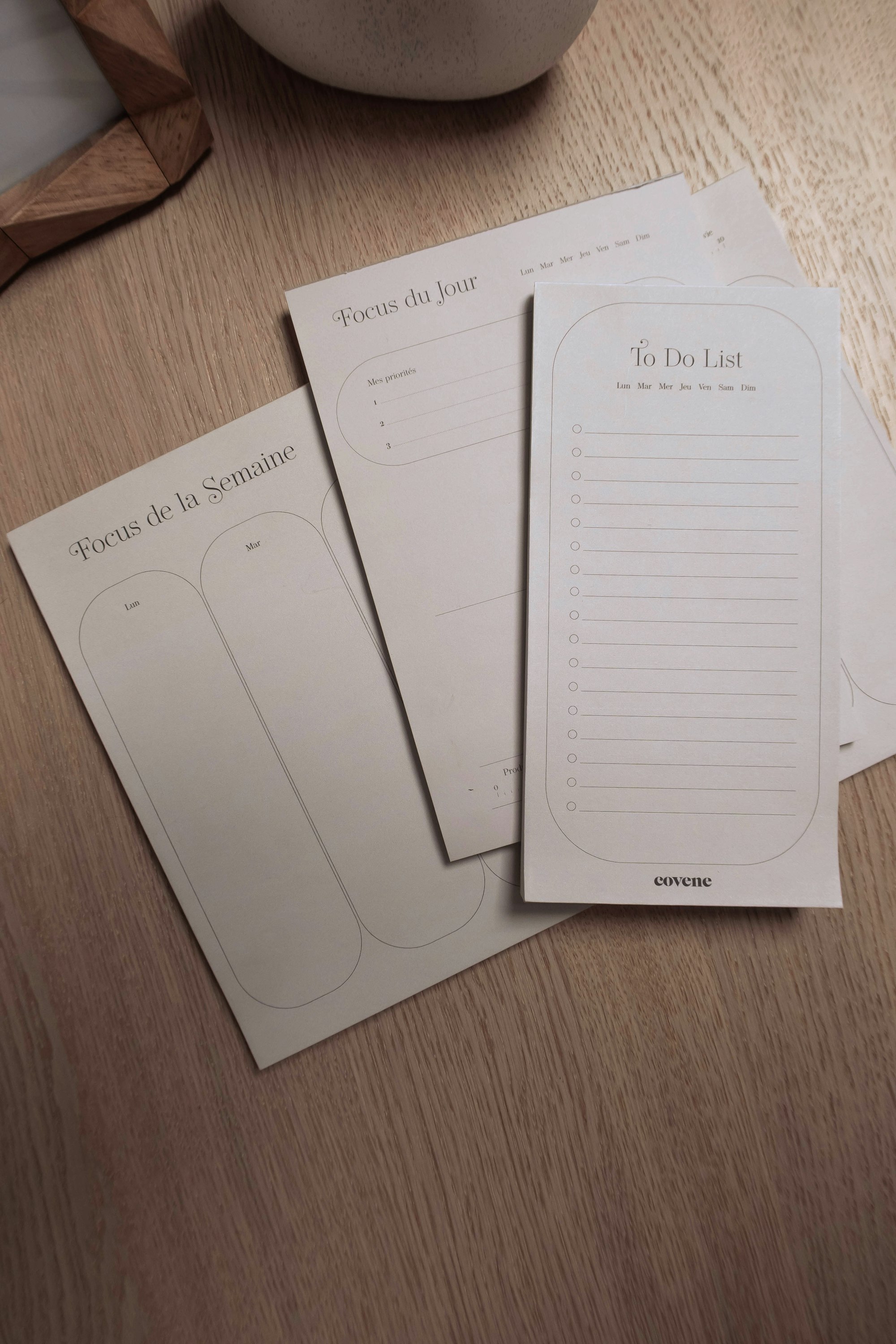 Three notebooks sitting on top of a wooden table