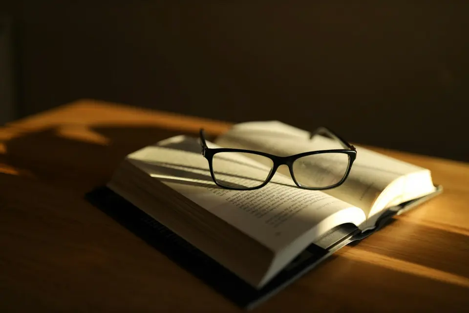 Black framed eyeglasses resting on an open book page