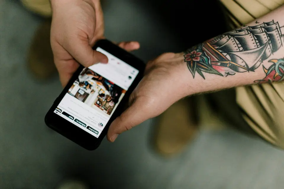 Hands holding a smartphone displaying a social media feed