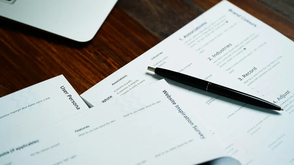 Black pen resting on printed invoices
