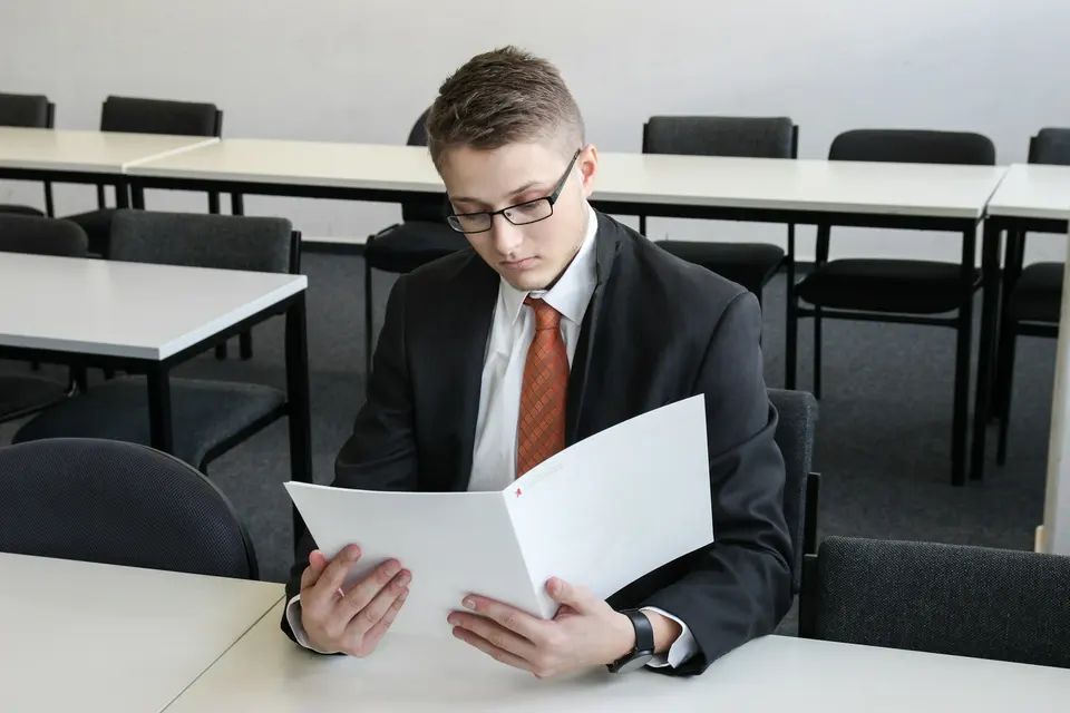 Man holding folder confidently in an empty room