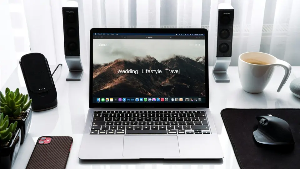 MacBook Pro beside white ceramic mug on desk