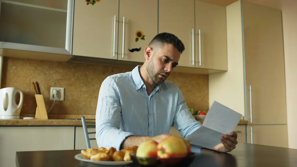 Person reading a paper at a kitchen table