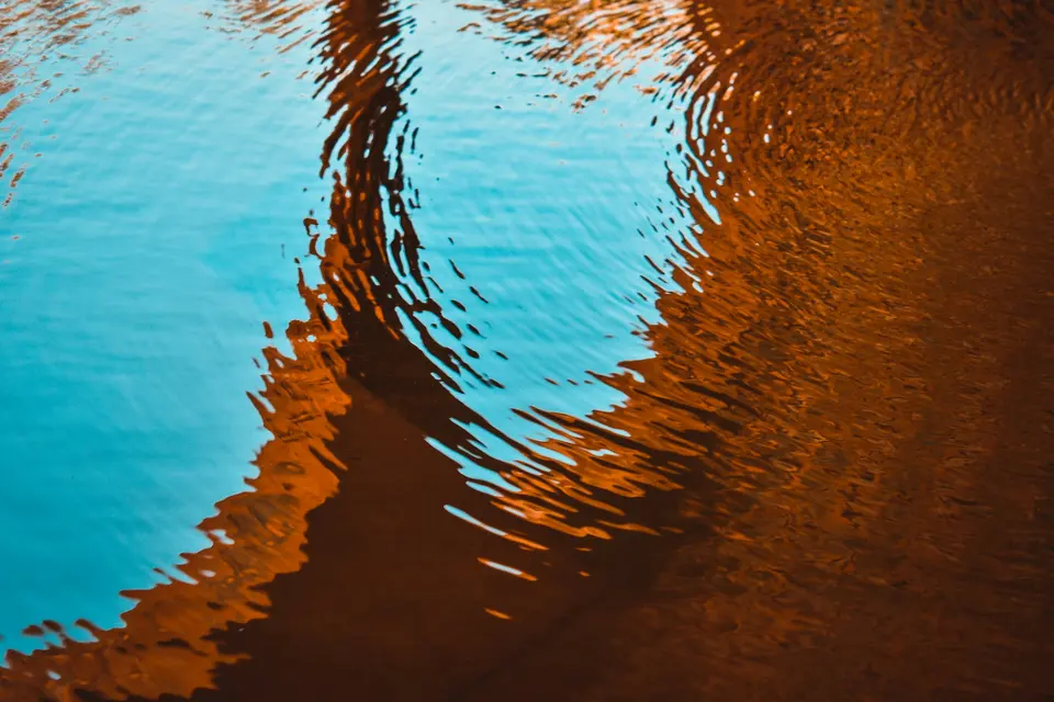 Blue and orange reflections rippling across water